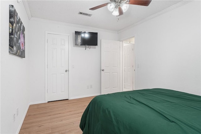 bedroom with hardwood / wood-style flooring, crown molding, and ceiling fan