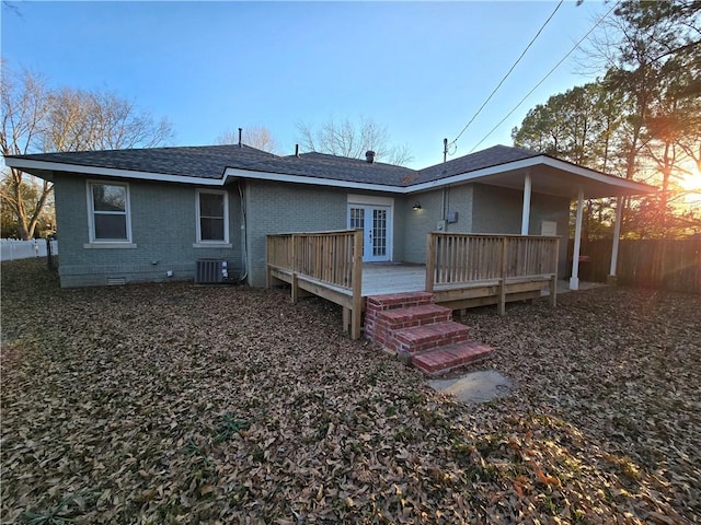 back of house with central AC unit, a deck, and french doors