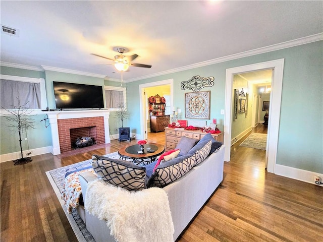 living room featuring crown molding, ceiling fan, wood-type flooring, and a fireplace