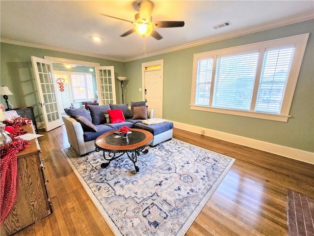 living room featuring crown molding, a healthy amount of sunlight, wood-type flooring, and french doors