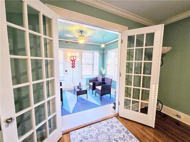 entryway with crown molding, ceiling fan, wood-type flooring, and french doors