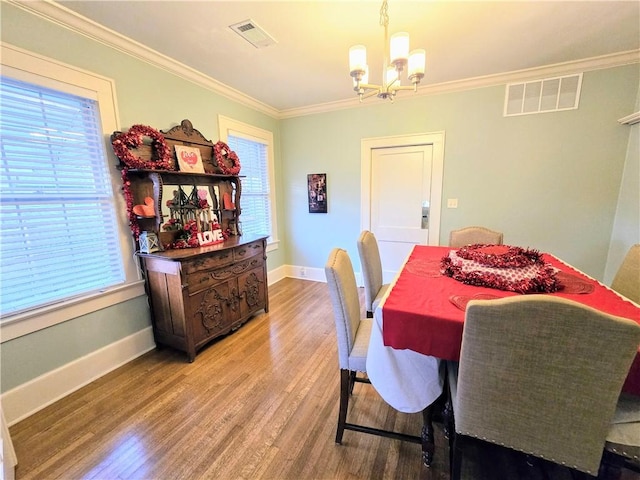 dining room featuring crown molding, plenty of natural light, hardwood / wood-style floors, and a chandelier