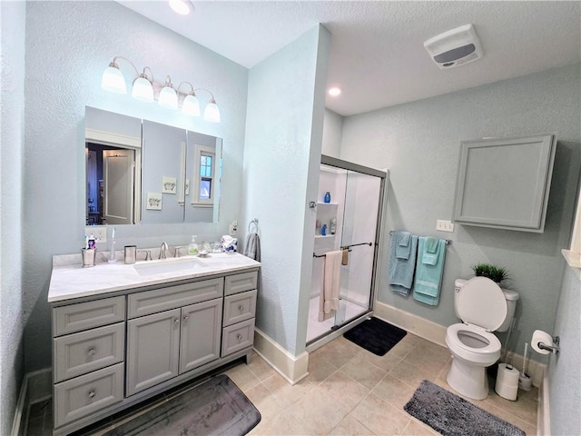 bathroom featuring vanity, toilet, a shower with shower door, and tile patterned flooring