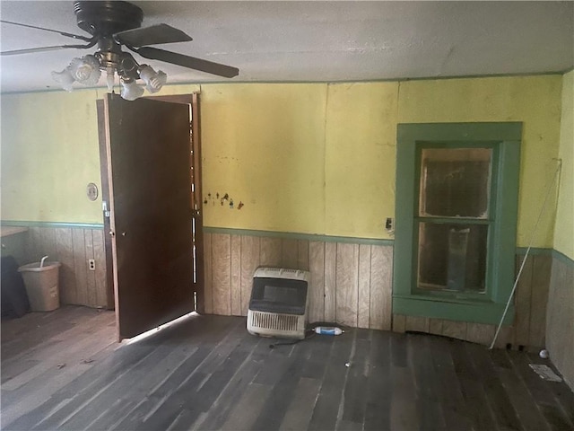 unfurnished living room with heating unit, a textured ceiling, dark hardwood / wood-style floors, and ceiling fan