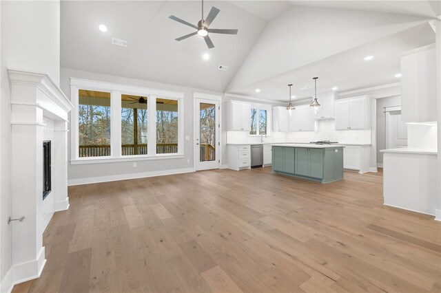 unfurnished living room featuring sink, light hardwood / wood-style flooring, high vaulted ceiling, and ceiling fan