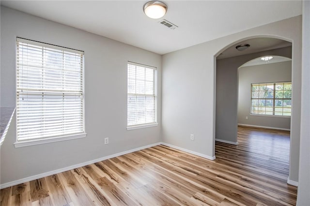 spare room featuring plenty of natural light and light hardwood / wood-style floors