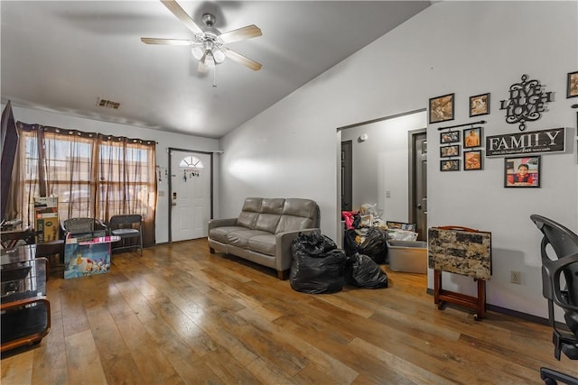 living room featuring ceiling fan, vaulted ceiling, and wood-type flooring