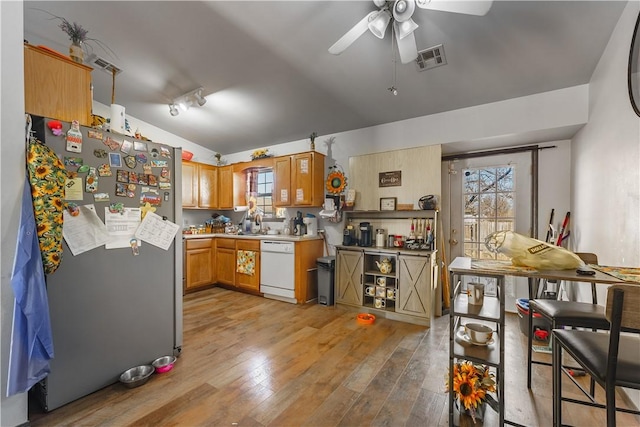 kitchen with stainless steel refrigerator, lofted ceiling, ceiling fan, white dishwasher, and light hardwood / wood-style floors