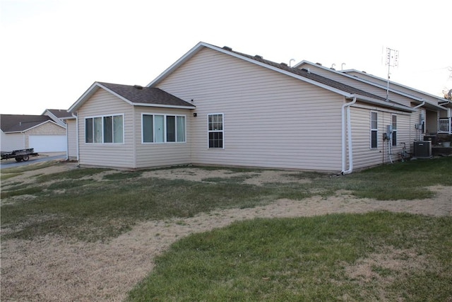 view of side of home with cooling unit and a lawn