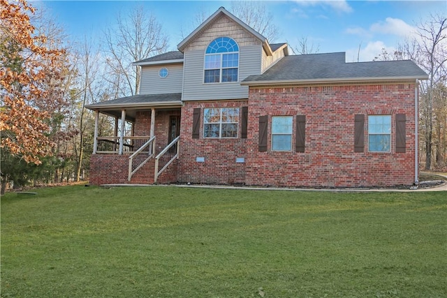 traditional home featuring a front yard, roof with shingles, brick siding, and a porch