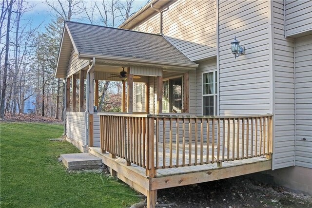deck with a ceiling fan and a yard