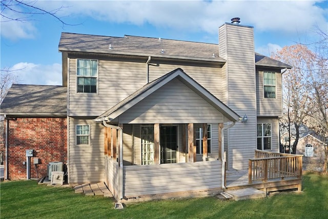 back of house featuring a wooden deck, a sunroom, a yard, and central air condition unit