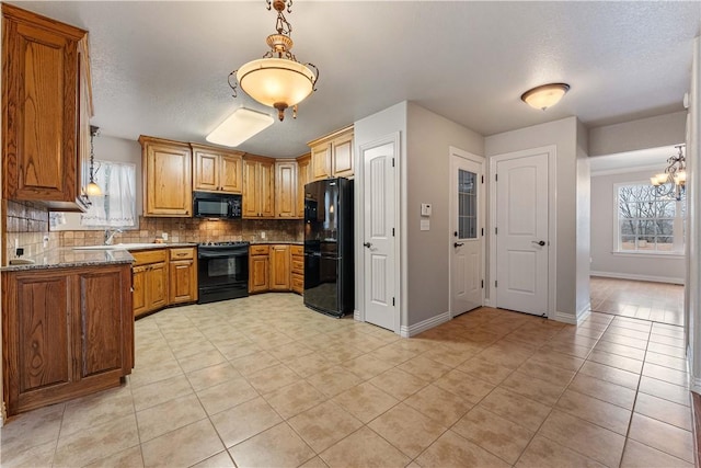 kitchen featuring black appliances, plenty of natural light, decorative backsplash, light tile patterned floors, and a textured ceiling