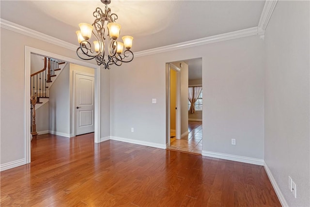 spare room with ornamental molding, a chandelier, wood finished floors, baseboards, and stairs