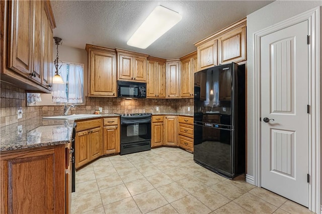 kitchen with sink, stone counters, tasteful backsplash, black appliances, and decorative light fixtures