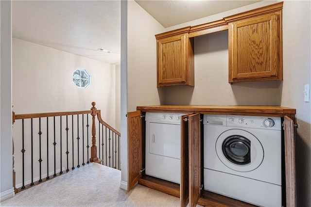 washroom with washing machine and clothes dryer, light colored carpet, cabinet space, and baseboards