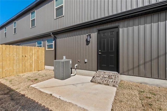 view of exterior entry featuring cooling unit and a patio area