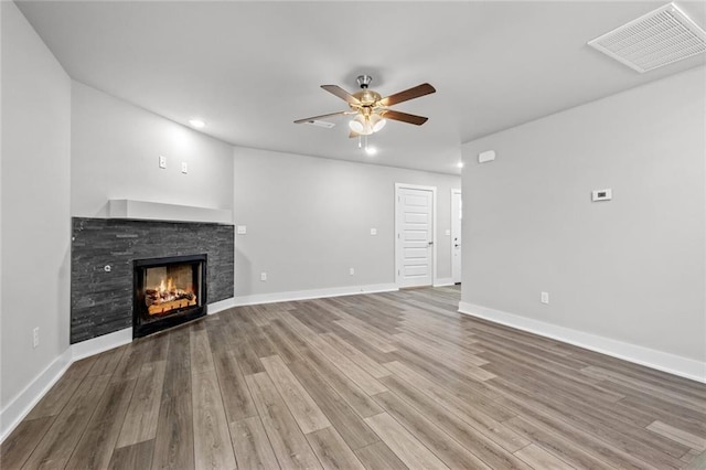 unfurnished living room featuring wood-type flooring, a fireplace, and ceiling fan