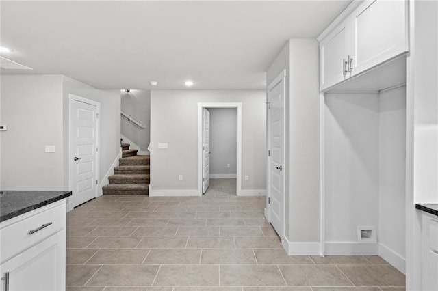 kitchen featuring white cabinetry and dark stone countertops