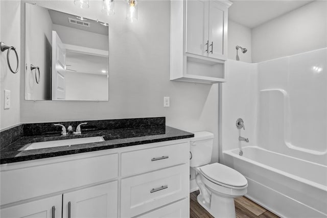 full bathroom with vanity, hardwood / wood-style floors, toilet, and shower / bath combination