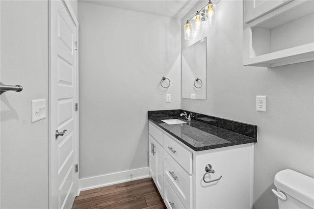 bathroom with vanity, toilet, and hardwood / wood-style floors