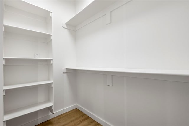 walk in closet with hardwood / wood-style flooring