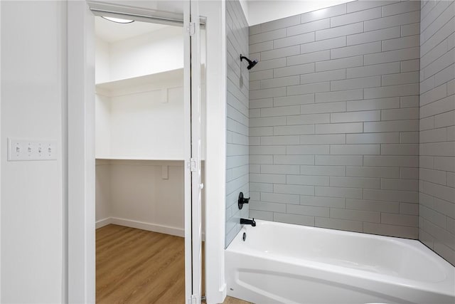 bathroom featuring tiled shower / bath combo and hardwood / wood-style flooring