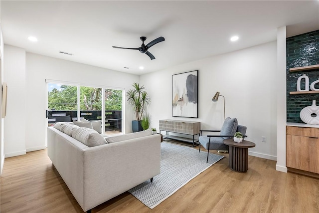 living room with ceiling fan and light hardwood / wood-style flooring