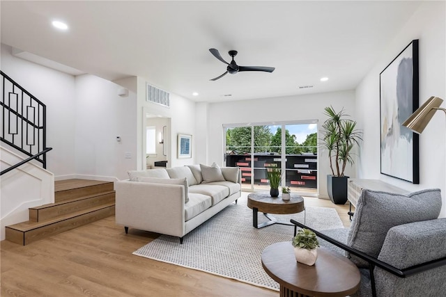 living room with ceiling fan and light hardwood / wood-style flooring