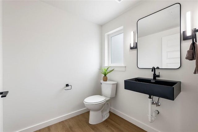 bathroom featuring sink, toilet, and wood-type flooring