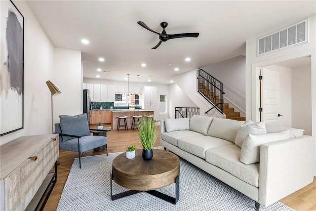 living room with light hardwood / wood-style floors and ceiling fan