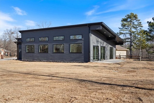 view of side of property featuring a patio and a lawn