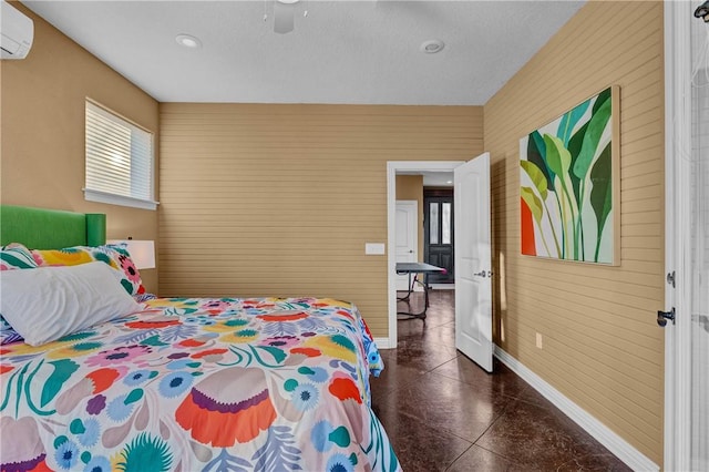 bedroom with ceiling fan and a wall unit AC