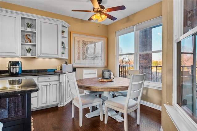 dining space with dark hardwood / wood-style floors and ceiling fan