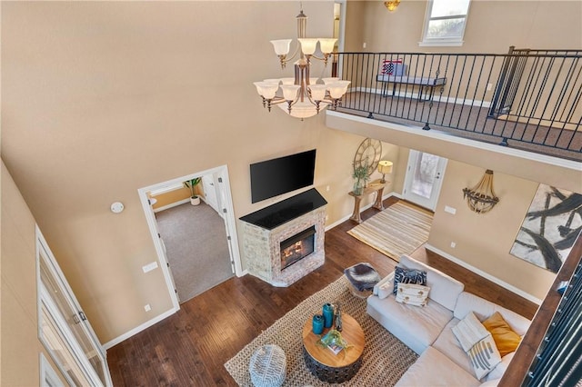 living room featuring dark wood-type flooring, a towering ceiling, and a notable chandelier