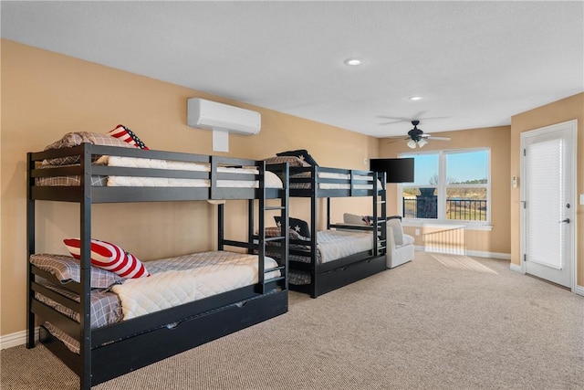 carpeted bedroom with ceiling fan and a wall mounted air conditioner