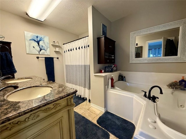 bathroom featuring vanity, a bathing tub, tile patterned flooring, and a textured ceiling