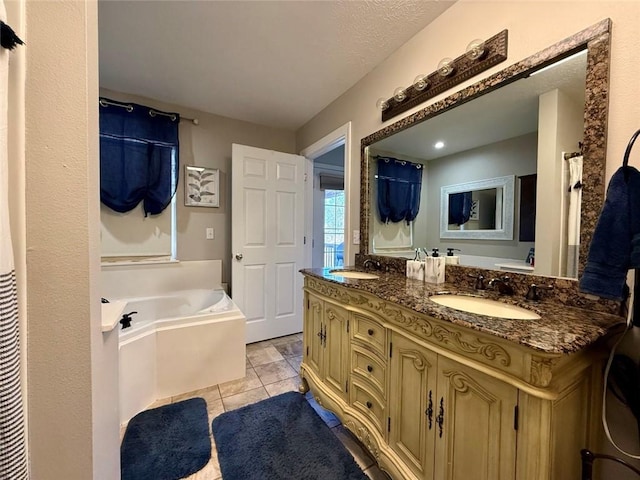 bathroom featuring tile patterned flooring, vanity, a bathtub, and a textured ceiling