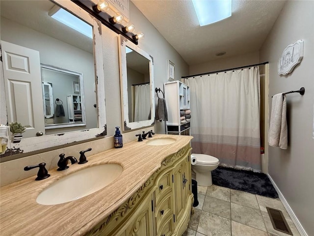 bathroom featuring tile patterned flooring, vanity, a textured ceiling, and toilet