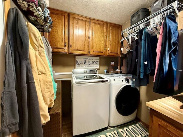 laundry area featuring cabinets, a textured ceiling, and independent washer and dryer