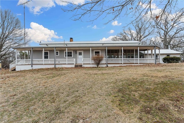 farmhouse featuring covered porch and a front yard