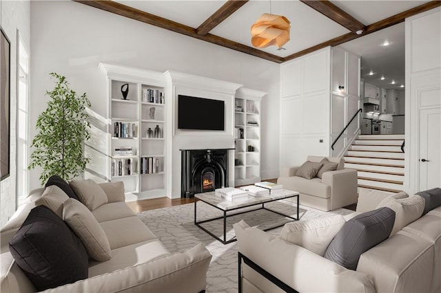 living room featuring beam ceiling and light hardwood / wood-style floors