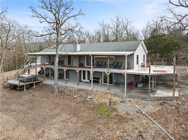 rear view of house featuring a chimney, stairway, and a patio