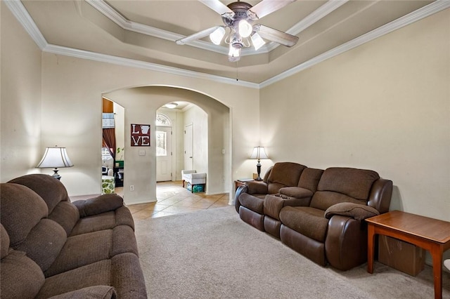 living room with crown molding, ceiling fan, a raised ceiling, and light tile patterned floors