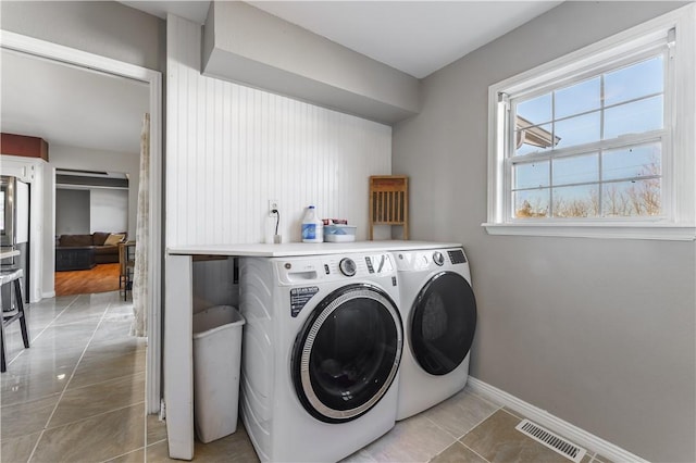 laundry area featuring laundry area, light tile patterned floors, baseboards, visible vents, and washer and clothes dryer