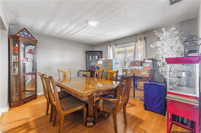 dining room with visible vents, baseboards, and wood finished floors