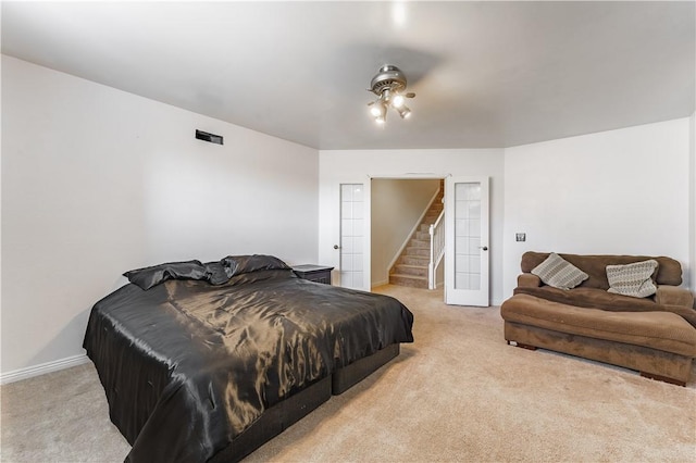 bedroom with french doors, light colored carpet, and baseboards