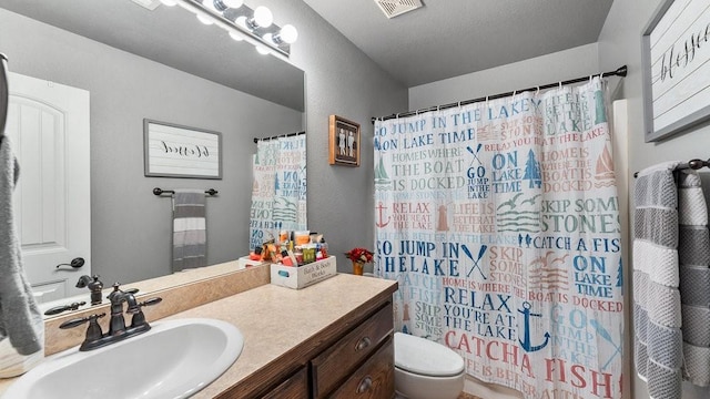 bathroom featuring a shower with curtain, vanity, and toilet