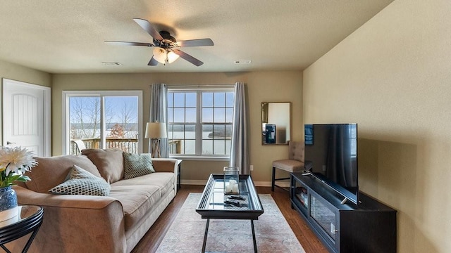 living room featuring a textured ceiling, dark hardwood / wood-style floors, and ceiling fan