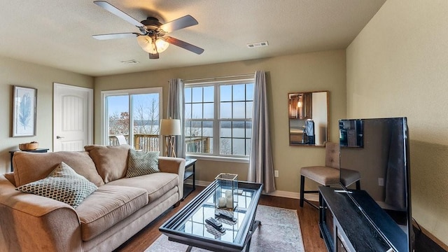 living room featuring hardwood / wood-style flooring, a textured ceiling, and ceiling fan